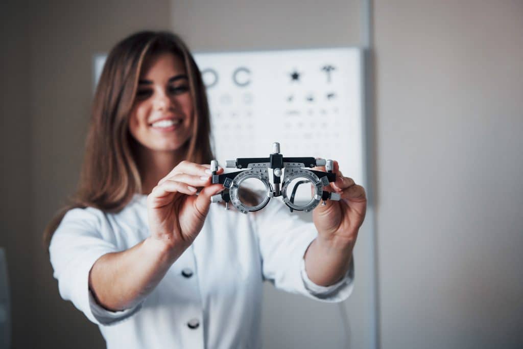 focus glasses female doctor standing office holding special eyeglasses with board testing visual acuity