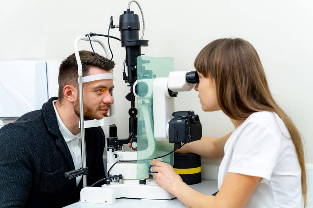 optometrist working his clinic examining eye vision ophtalmology medical healthcare diagnostic